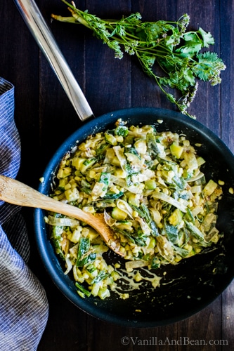  Creamy Corn, Zucchini and Poblano taco stuffing in a pan with a spoon. 