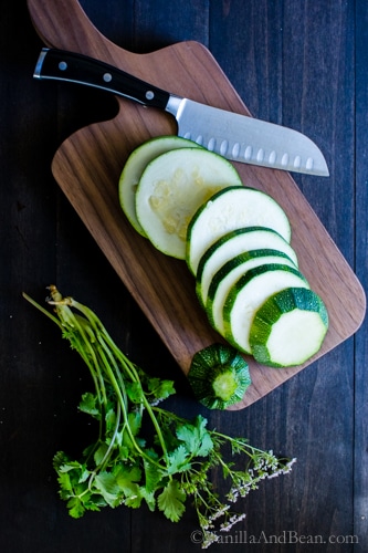 Sliced zucchini on a cutting board with a knife. 