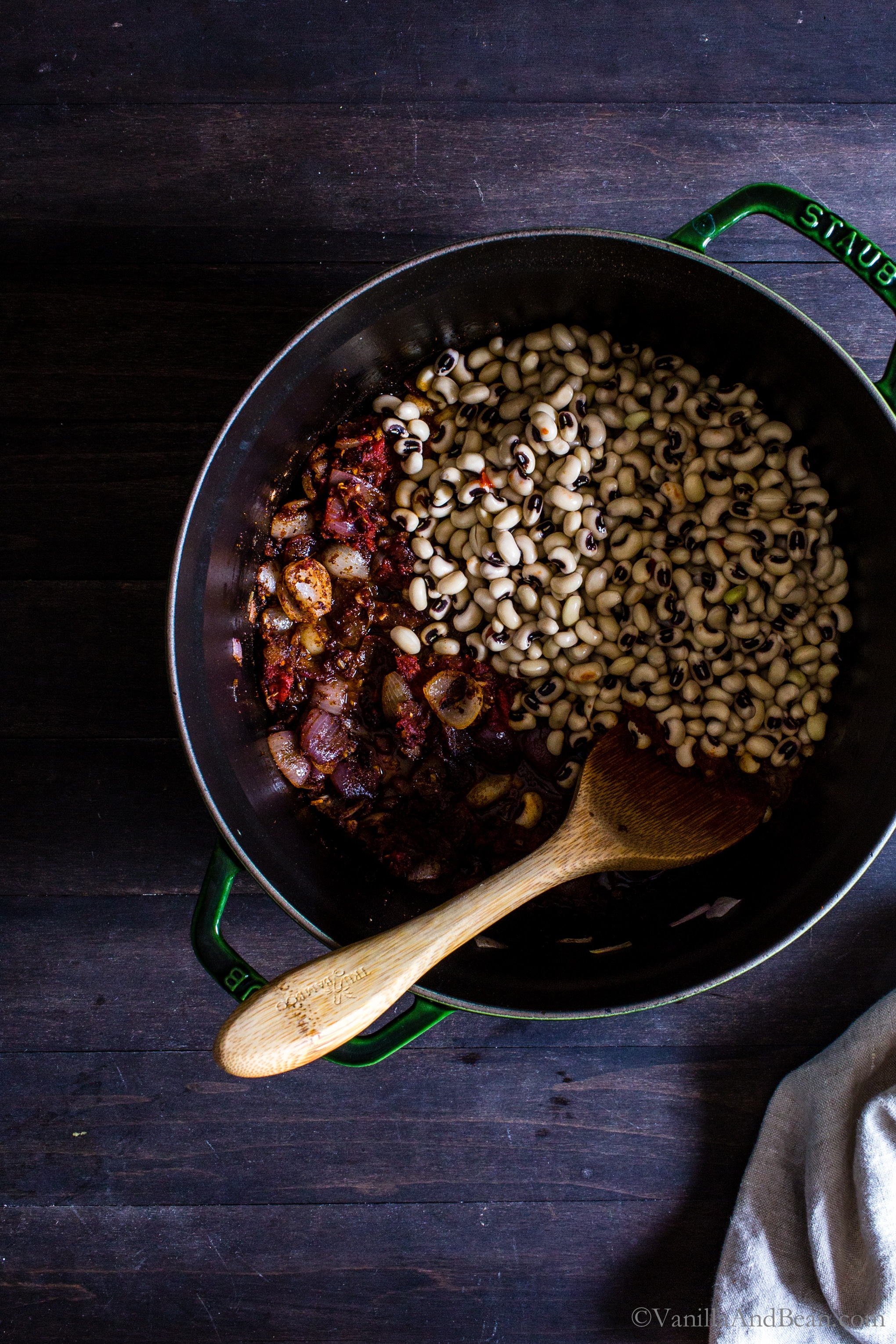 Adding soaked Black Eyed Peas to the Dutch oven with the onions and spices. 