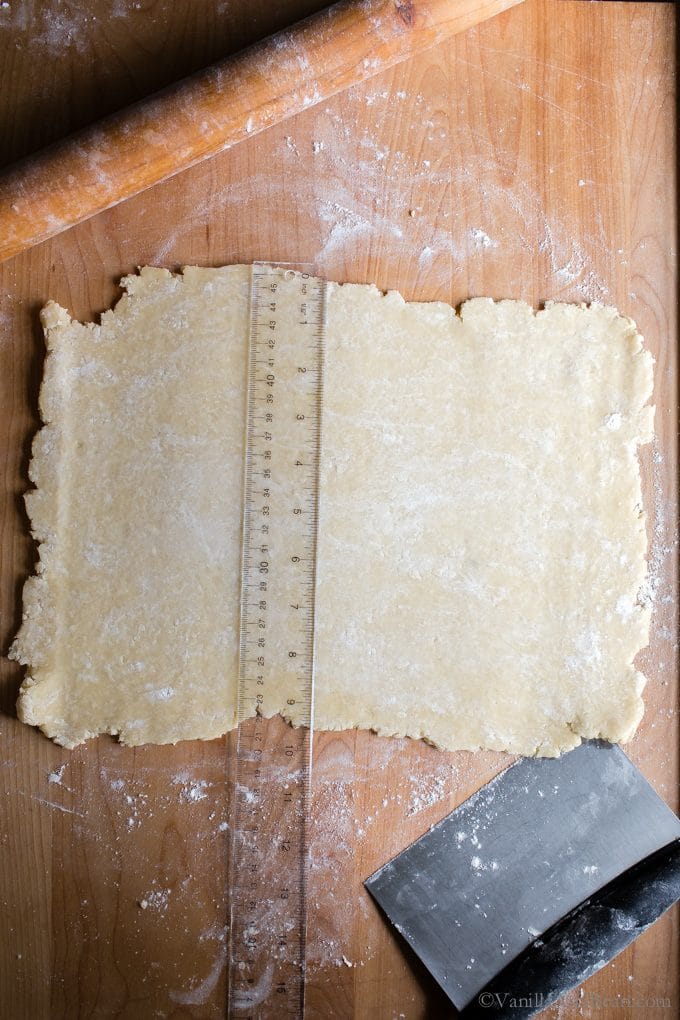 Measuring the pastry to cut into squares. 