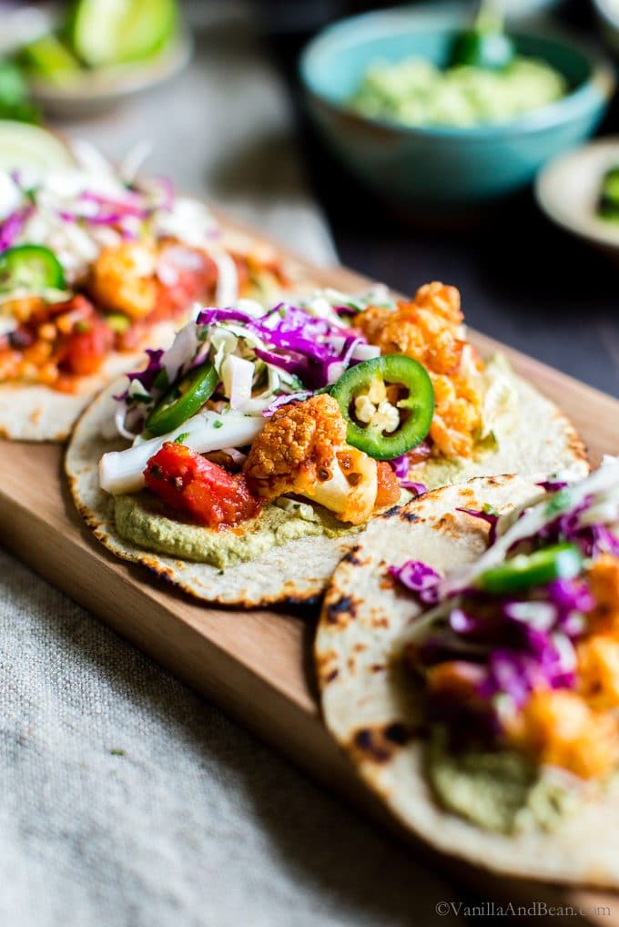 Roasted Cauliflower Tinga Tacos with Chili-Lime Slaw on a board. 