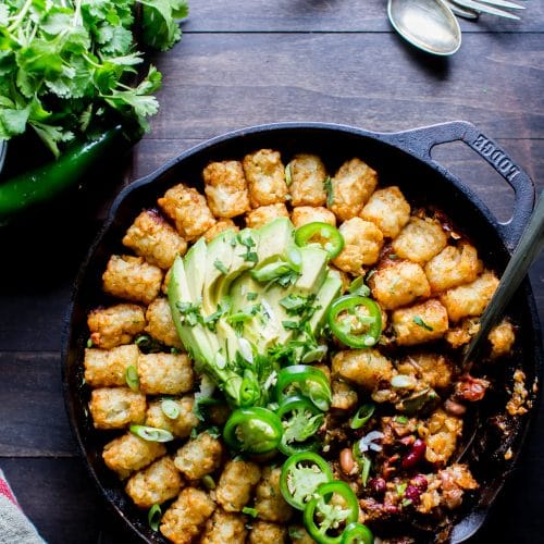 A skillet of chili covered in tater tots. 