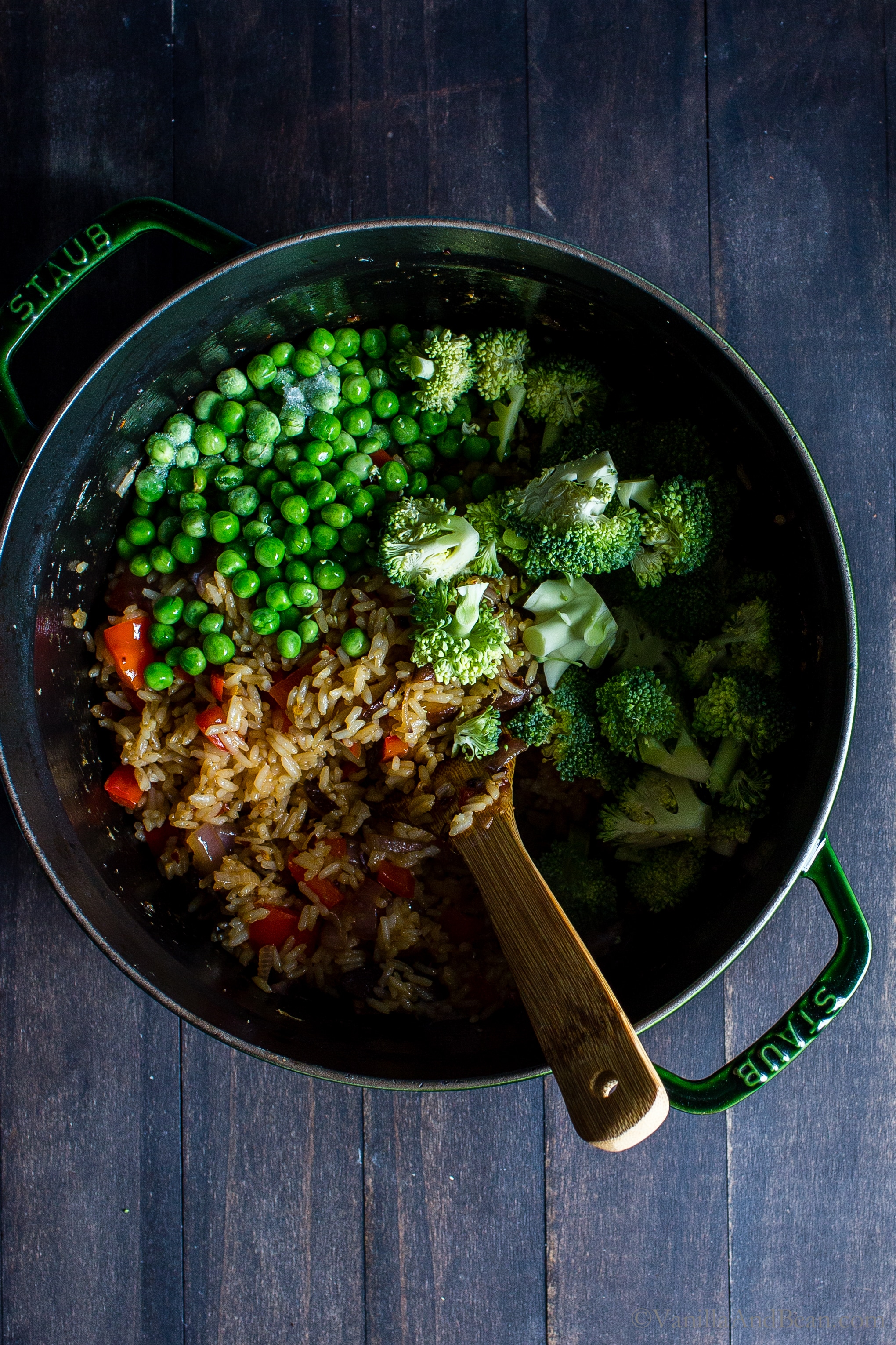 Adding sweet peas and broccoli to the stir fried rice and veggies in a Dutch oven. 