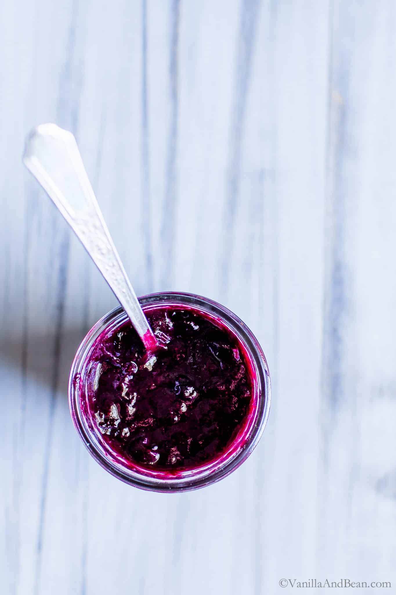 Blueberry Rhubarb Compote in a jar with a spoon. 