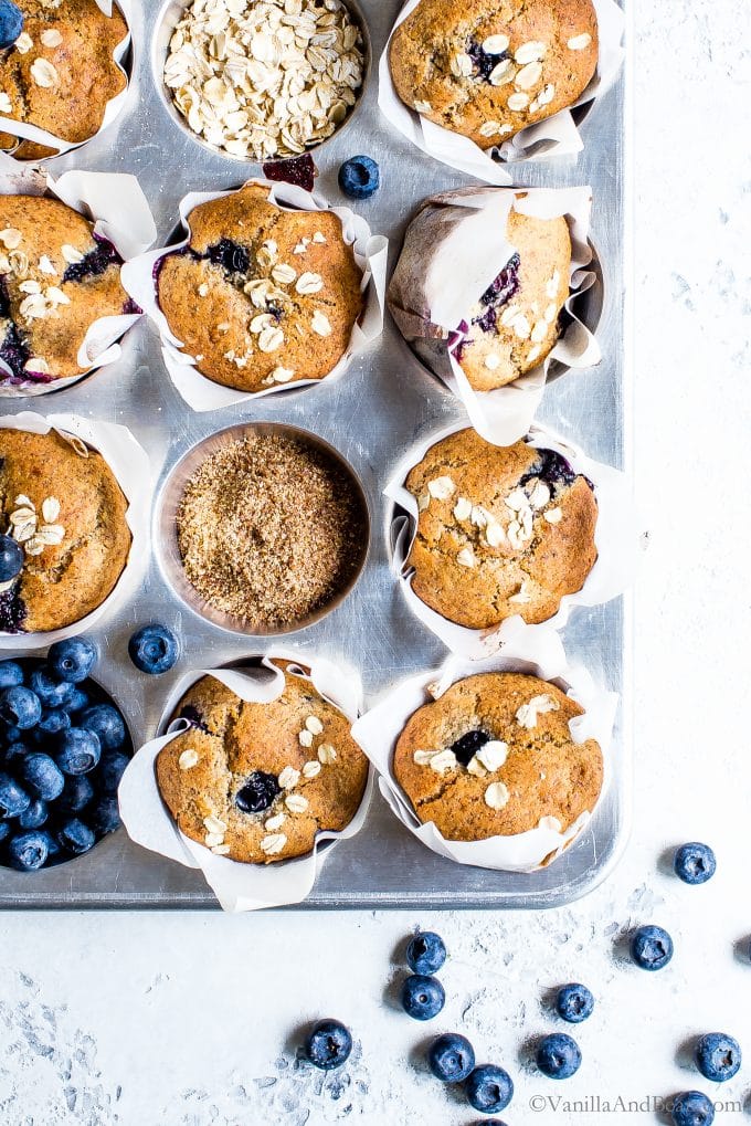 Overhead shot of naturally sweetened Blueberry-Oat Flax Muffins in a muffin pan. 