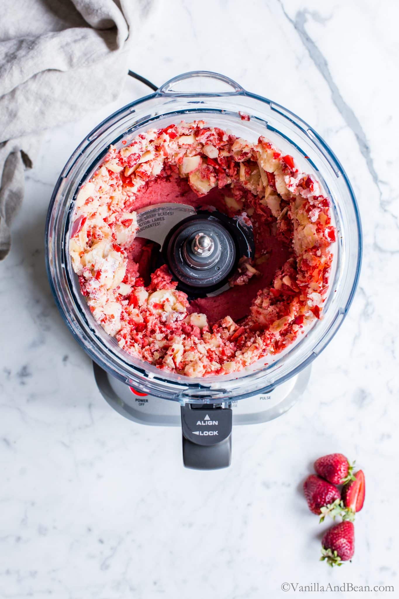 Processing the strawberries, bananas and coconut cream in a food processor. 