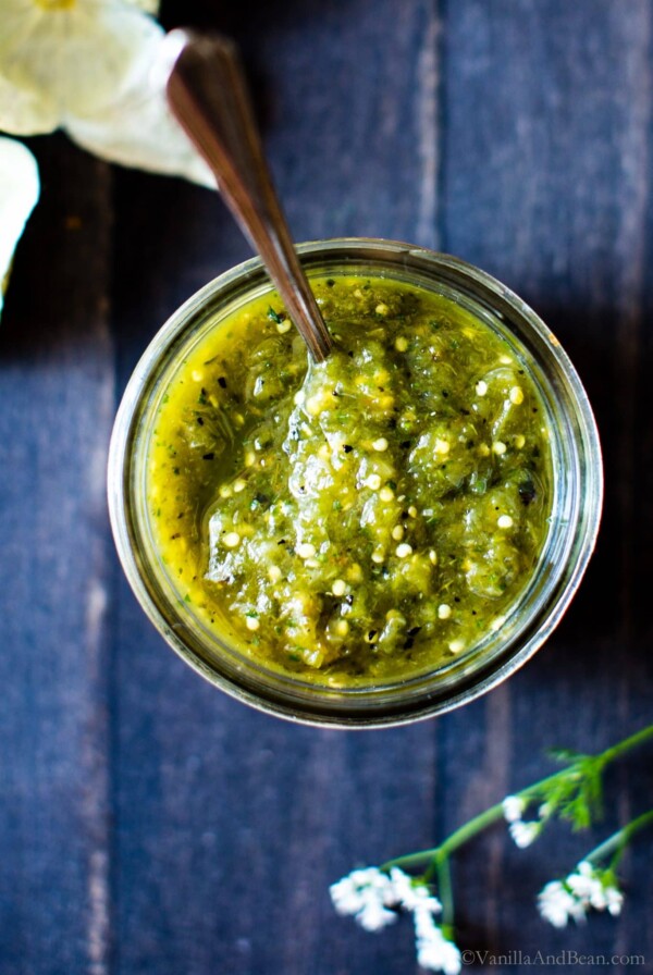 Roasted Tomatillo Salsa in a jar with a spoon!
