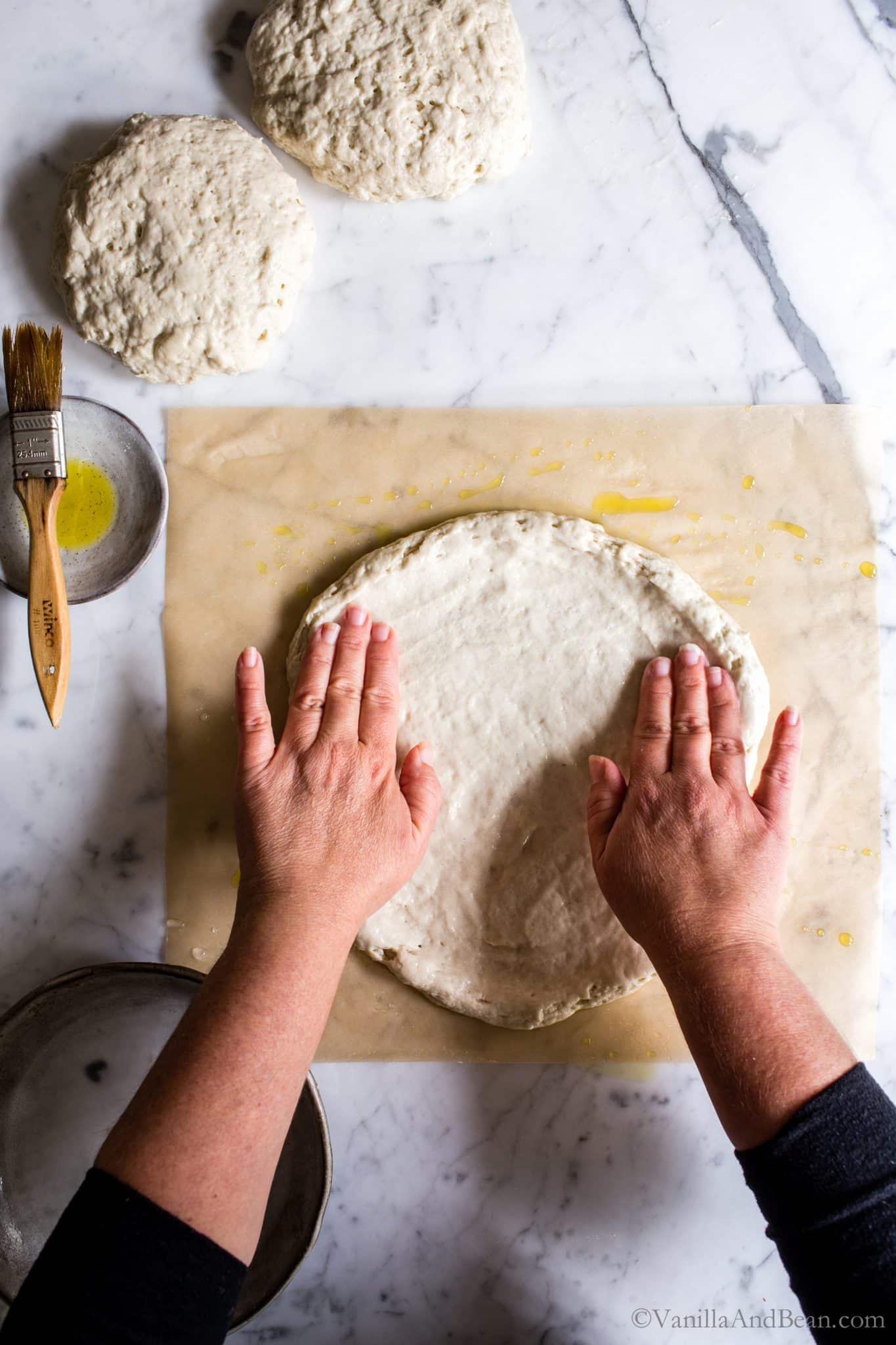 Working on the edges of the soon-to-be crust with two hands