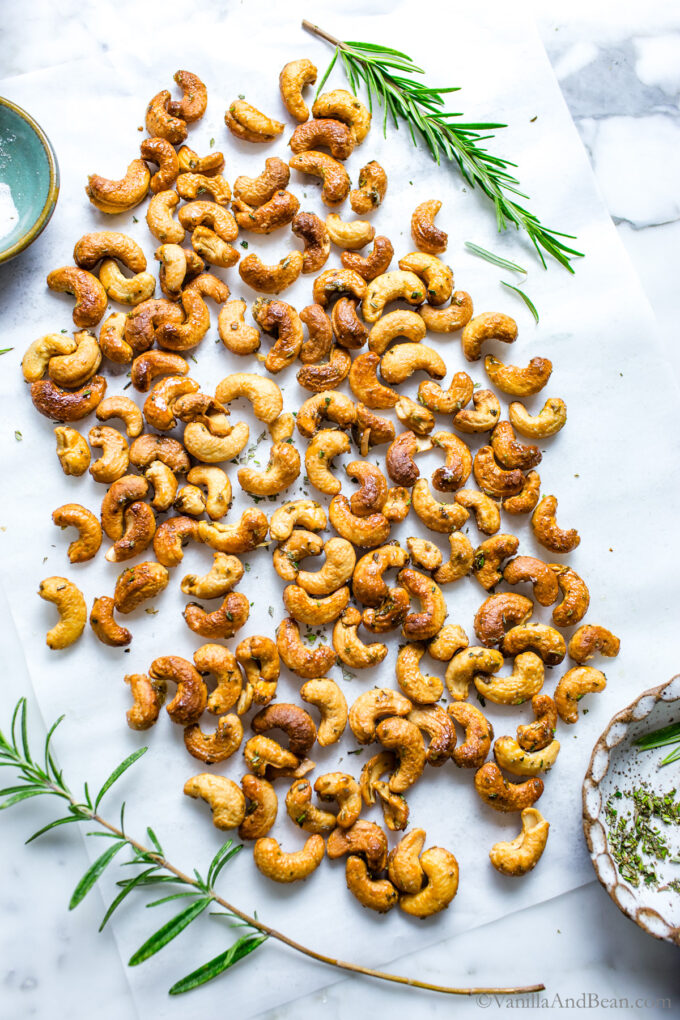 Maple spiced roasted cashews on a parchment paper after roasting.