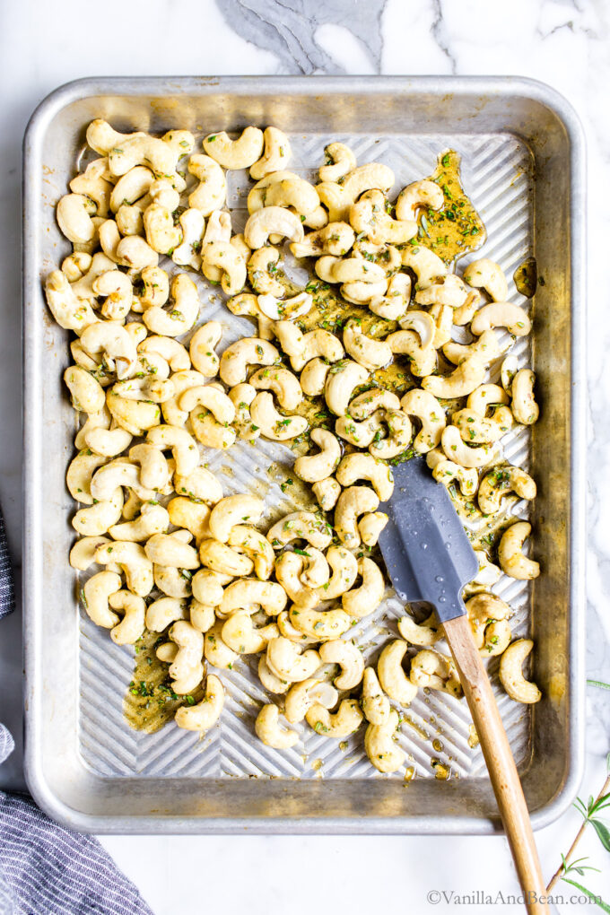 Maple roasted rosemary cashews on a sheet pan before roasting.