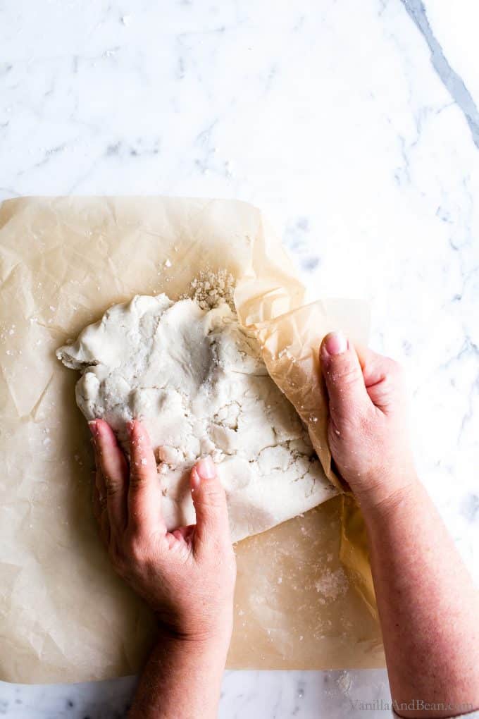 Shaping the gluten free pie pastry on parchment paper. 