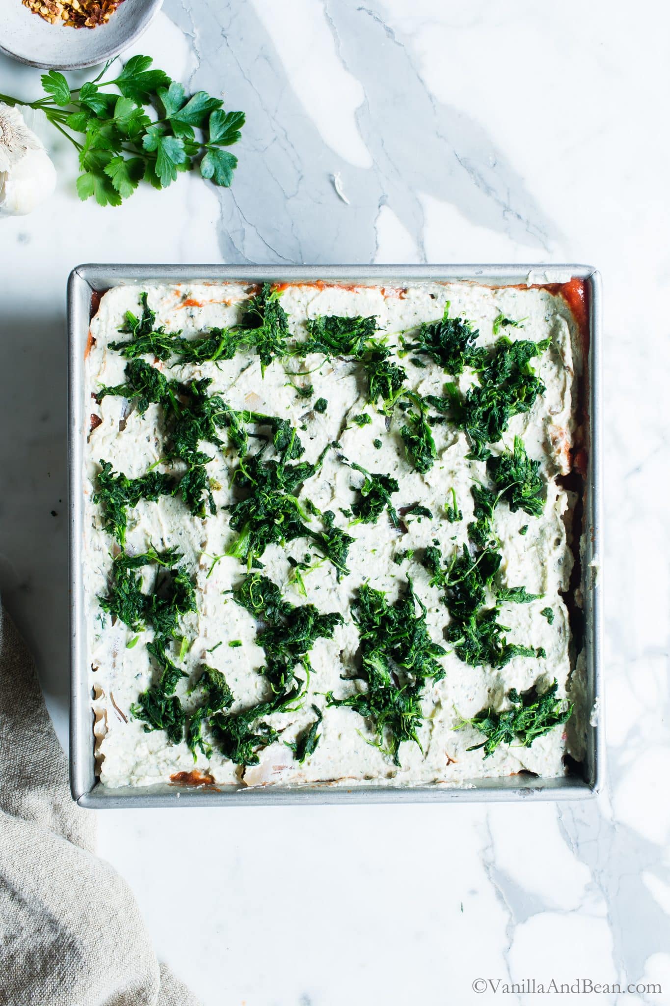 Layering the ricotta and spinach in the mushroom and spinach lasagna in a pan. 
