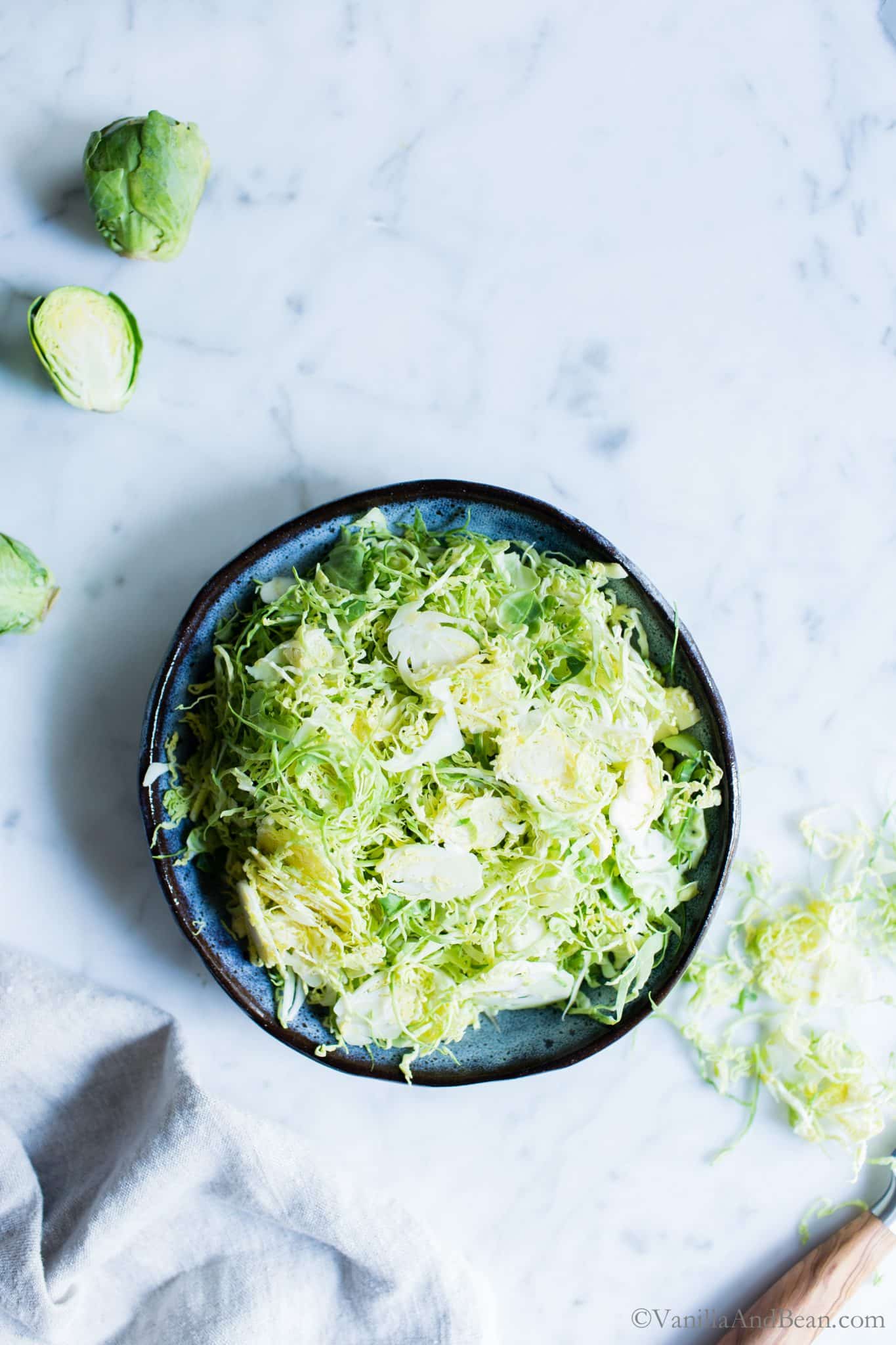 Shaved Brussels Sprouts in a blue bowl. 