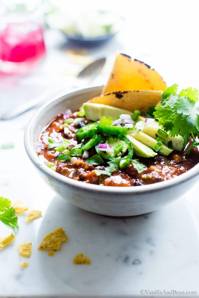 Slow Cooker Vegetarian Taco Soup in a bowl garnished with cilantro, peppers, avocado and tortilla. 