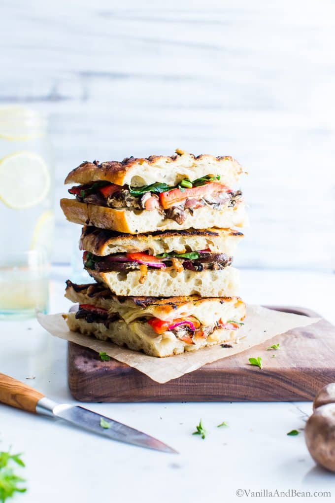 Veggie Panini Sandwiches stacked tall on a cutting board.
