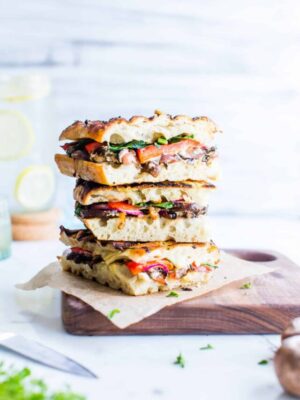 Veggie Panini Sandwiches stacked tall on a cutting board.