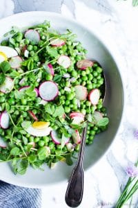 Sweet Pea Salad in a large bowl with a spoon ready to be shared.