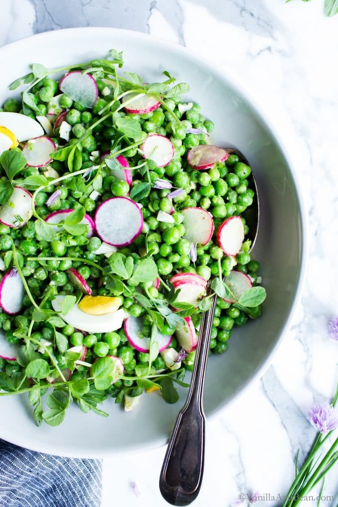 Sweet Pea Salad in a large bowl garnished with pea shoots. 