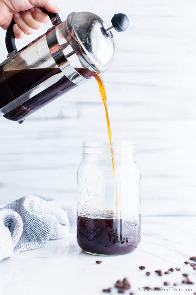 Pouring Cold Brew into a Mason jar from a French press. 