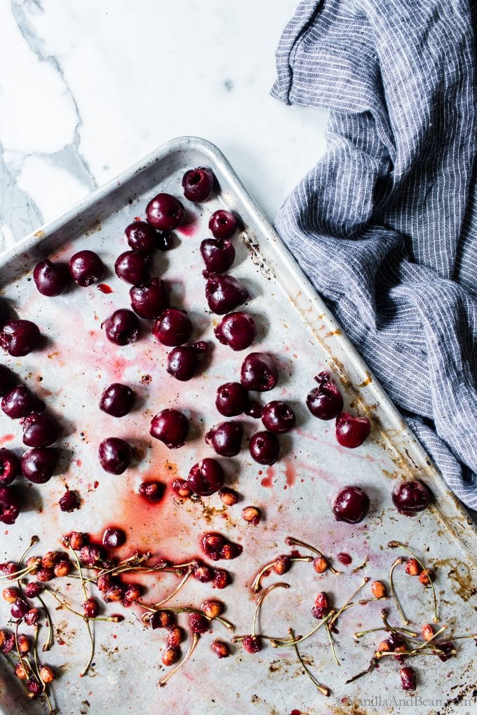 Pitting bing cherries on a tray