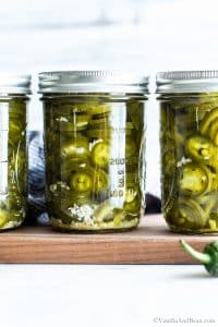A close up of pickled jalapenos in jars.