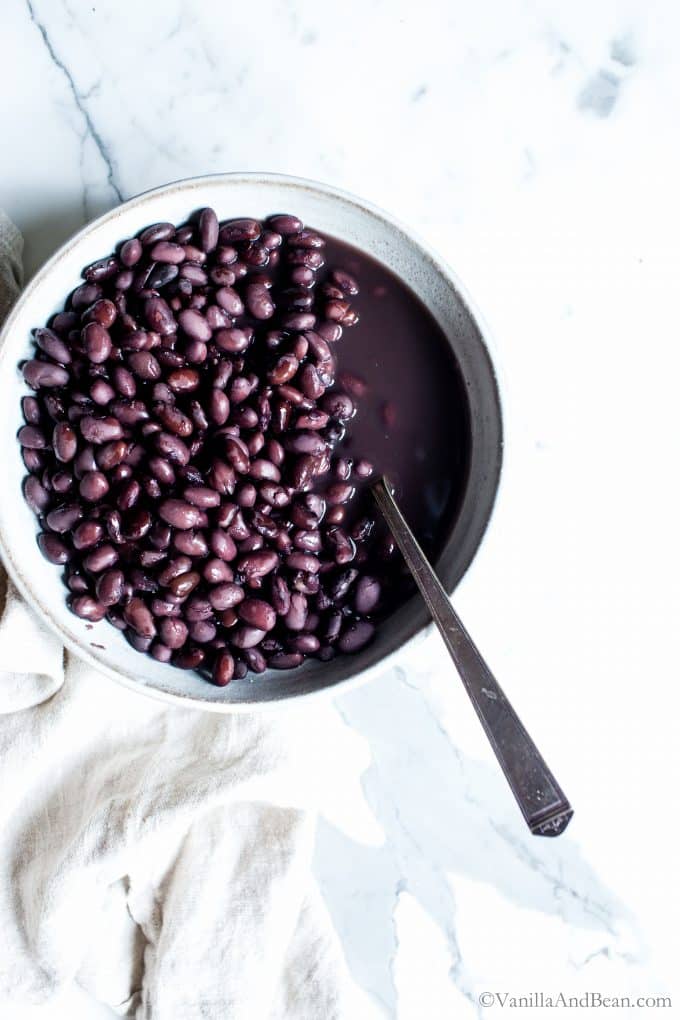 Cooked black beans on the stovetop in a bowl. 