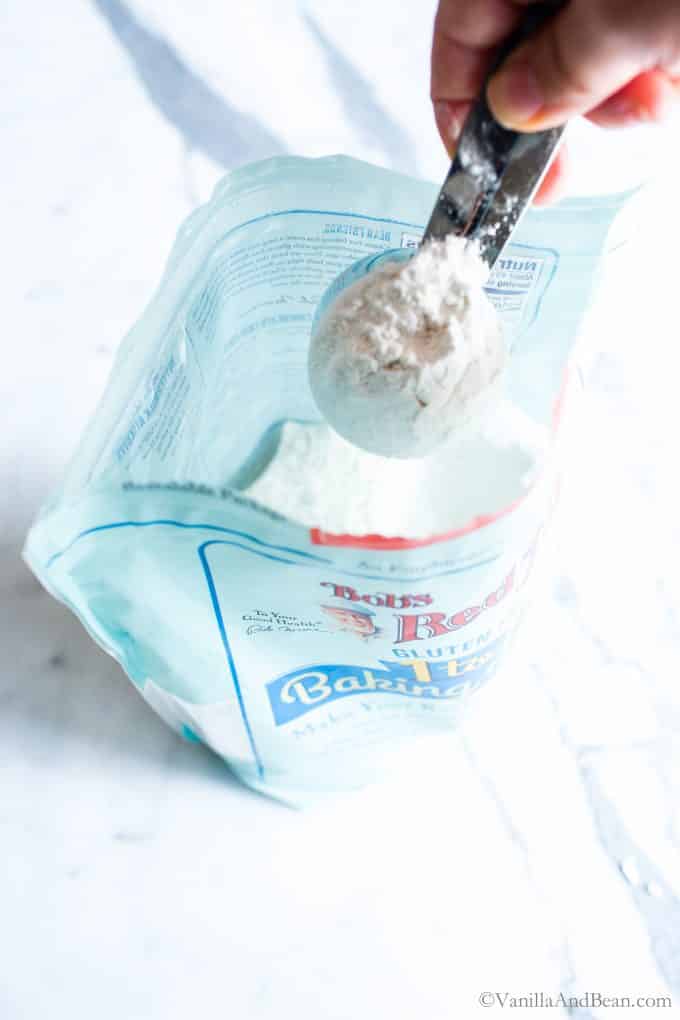 Scooping Bob's Red Mill 1 to 1 Baking Flour out of a bag. 
