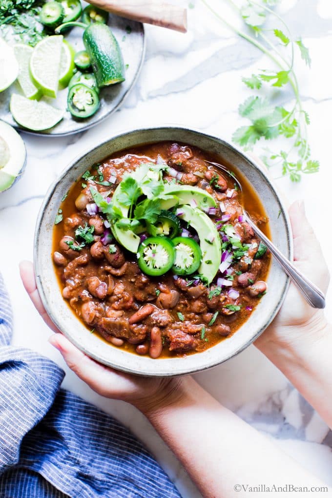Healthy Crock Pot Chili in a bowl with two hands holding it. 