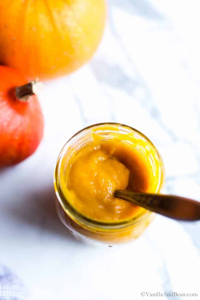 Pumpkin Puree in a jar with a spoon. 