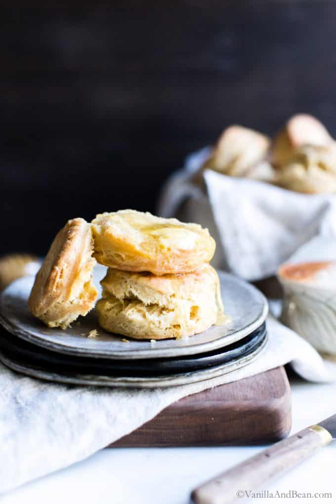 Sourdough Biscuit Recipe drizzled with a pat of butter and drizzled with honey on a plate. 