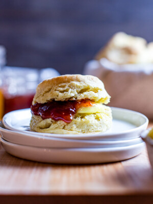 Sourdough discard biscuit with butter and jam on a plate.