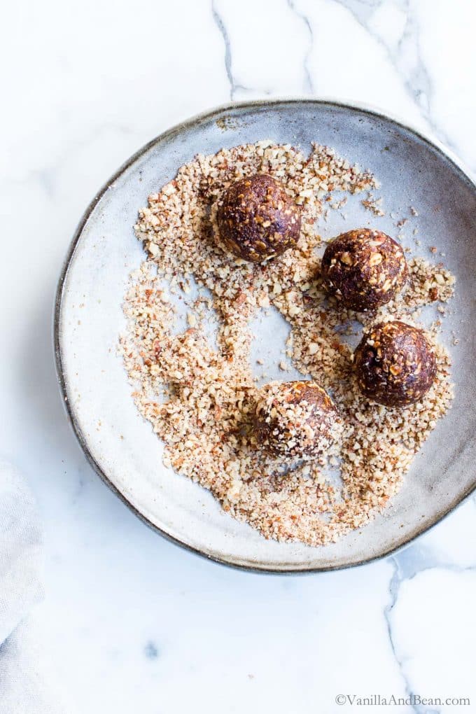 Rolling Bliss Balls in nuts. 