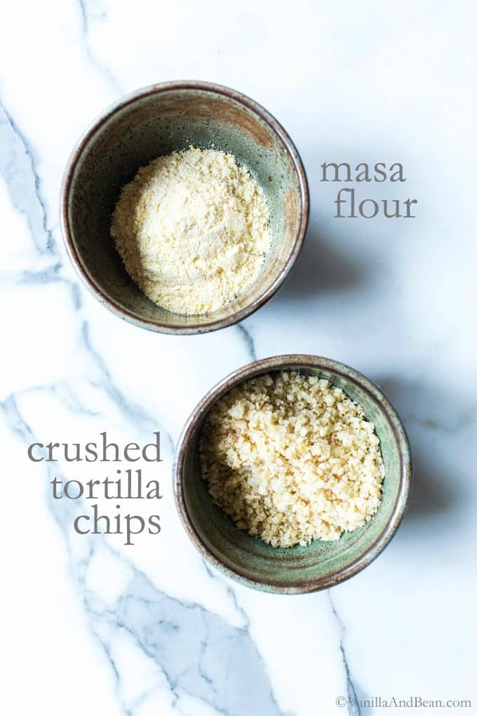 Overhead shot of masa flour and crushed tortilla chips in two separate bowls.