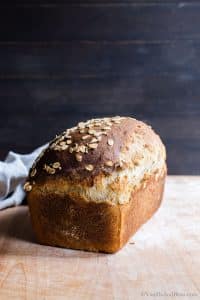 A sourdough sandwich bread loaf setting on a cutting board.