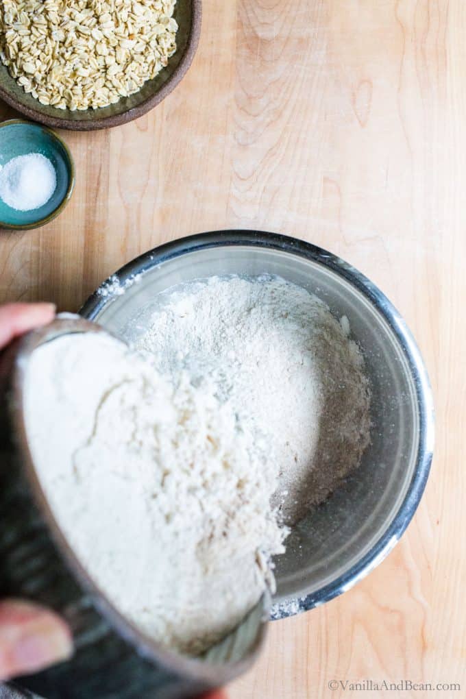 Adding flour to the wet sourdough ingredients.