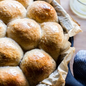 Sourdough dinner rolls brushed with butter.