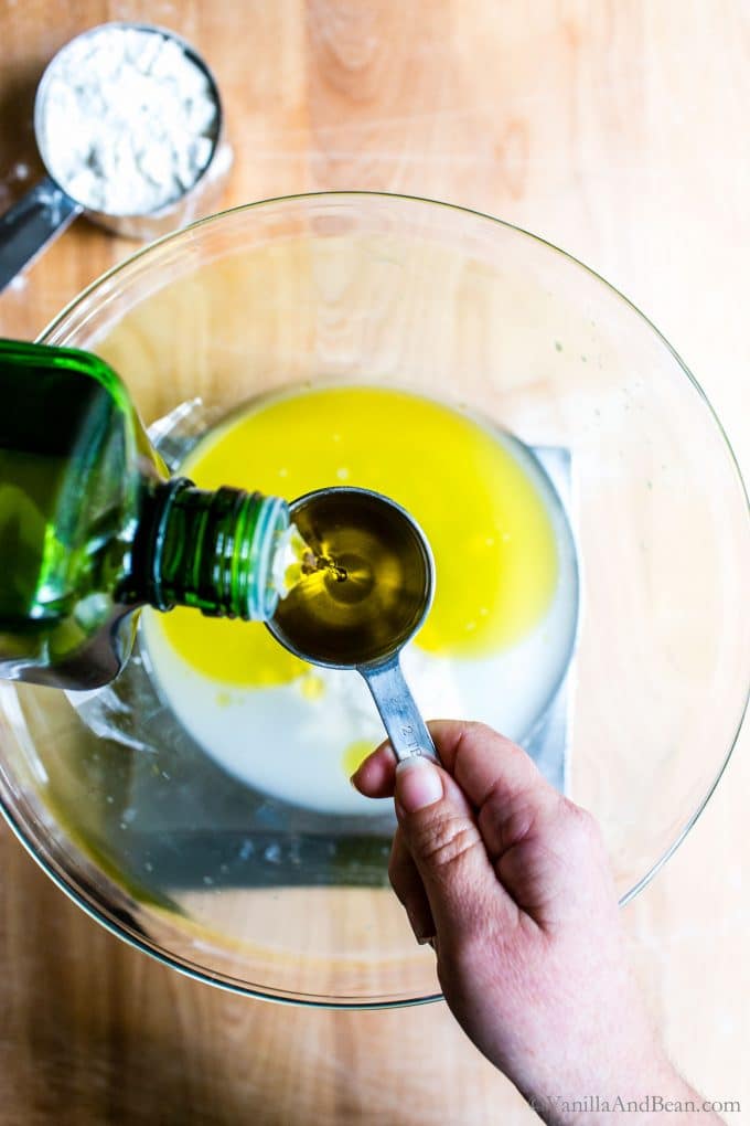 Pouring olive oil into a measuring spoon.