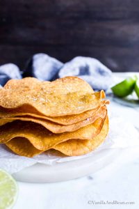 Large tostada shells stacked tall sprinkled with salt.