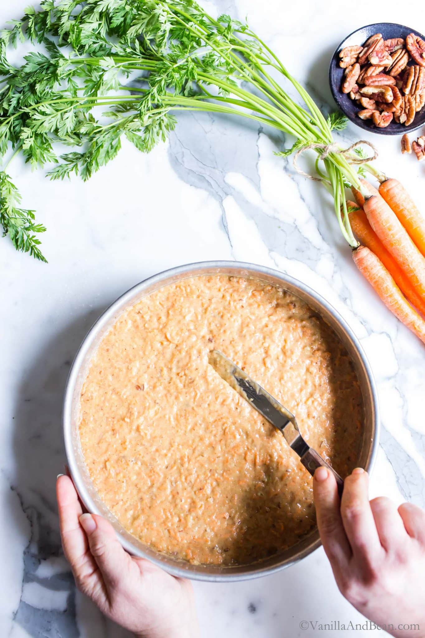 Smoothing Carrot Cake with pineapplebatter into a pan.