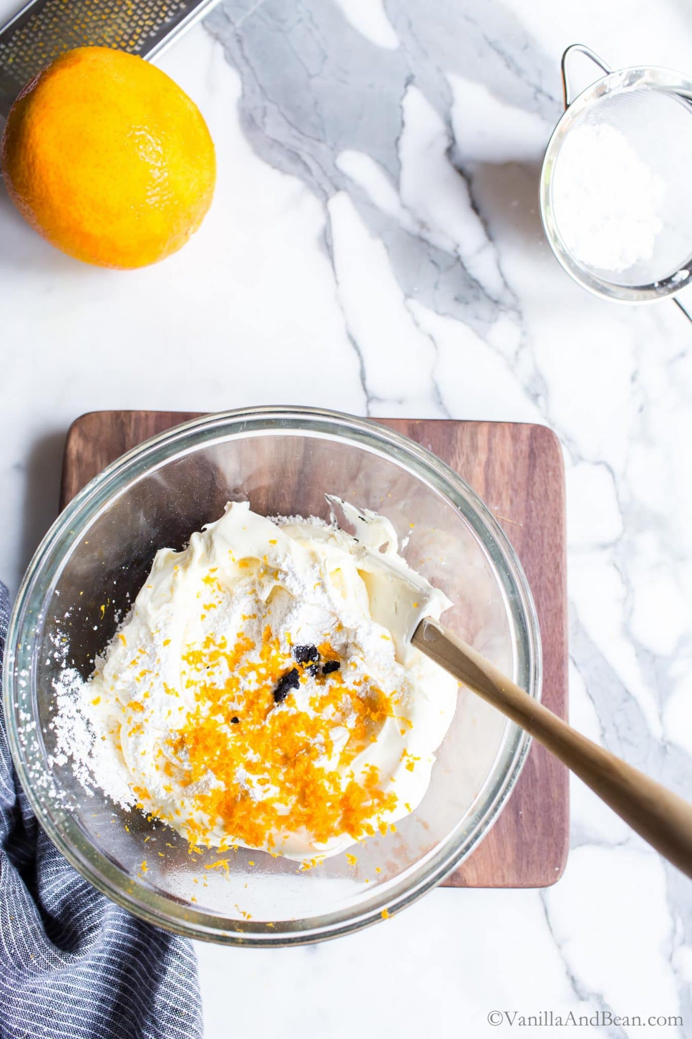 Mascarpone Frosting in a bowl with vanilla bean and orange zest.