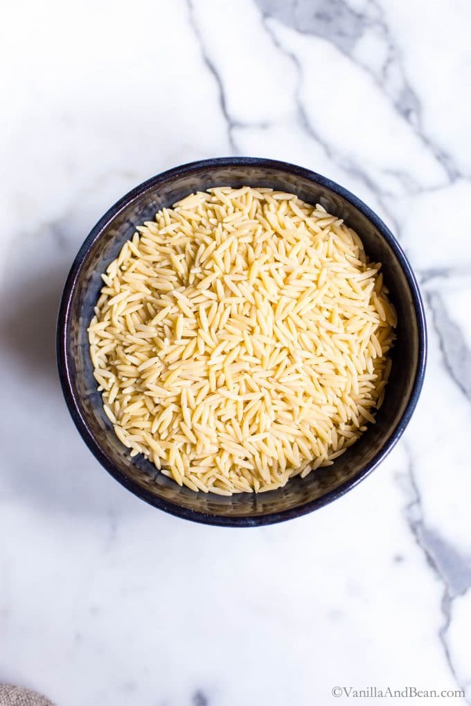 Dry Orzo pasta in a black bowl. 