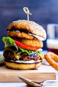 Closeup of Chickpea Burger with lettuce, tomato and onion rings between two buns.
