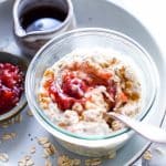 Overnight oats with peanut butter and jam in a glass jar with a spoon in it.