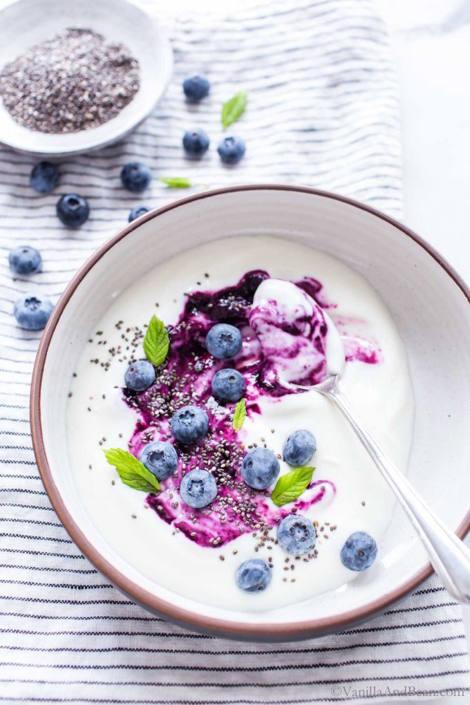 Blueberries compote recipe swirled into yogurt topped with fresh berries, chia and mint.