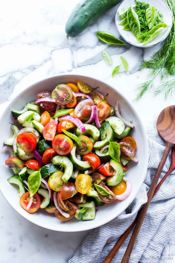 Tomato Cucumber and Onion Salad in a bowl with spoons on the side ready for sharing.