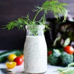 Dairy free ranch dressing recipe in a bottle with sprigs of dill coming out of the top.