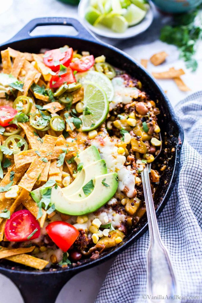 One Pan Mexican Quinoa Meal Vegetarian in a skillet garnished with jalapenos and avocados.