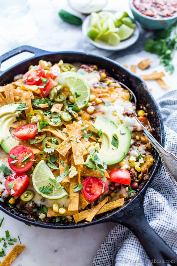 Yummy one pan Mexican Quinoa Vegetarian overhead shot garnished with lime, tomatoes, tortillas and sliced avocado. 