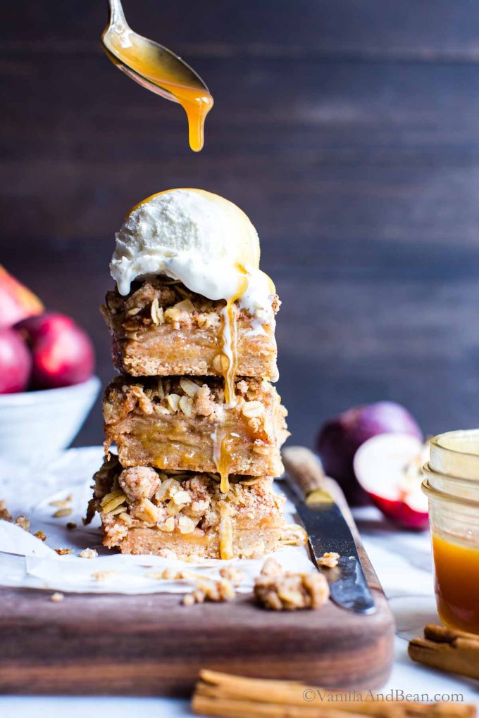Easy Apple Bars Recipe with shortbread crust and ice cream on top drizzled in caramel sauce.