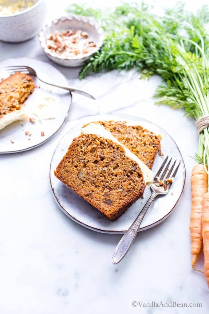 Carrot Cake Loaf Recipe sliced and on a plate with a fork ready to eat. 
